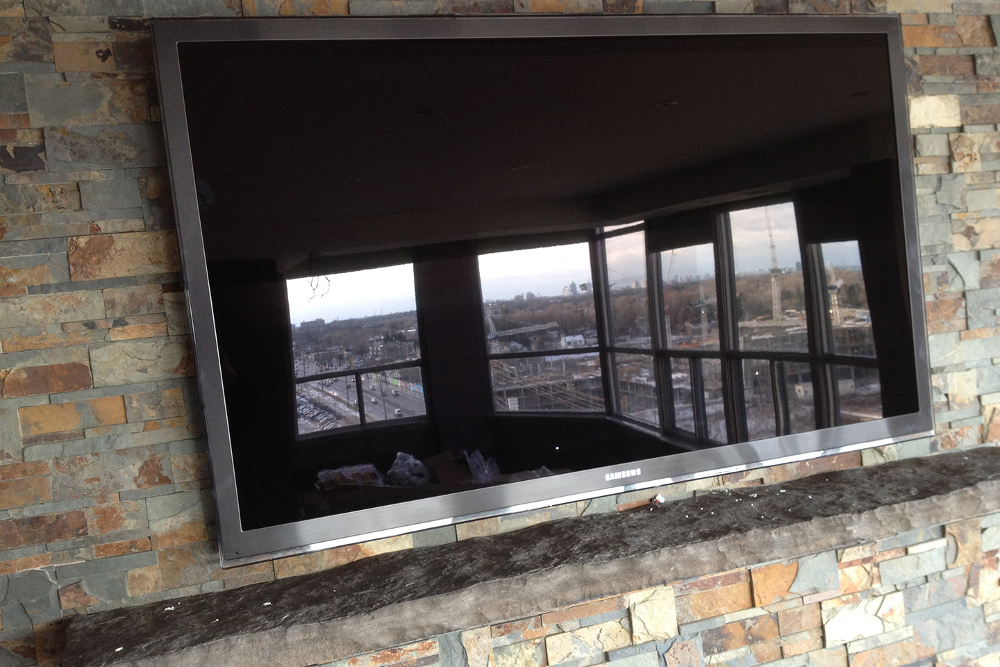 TV Above Fireplace on Slate Finished Wall